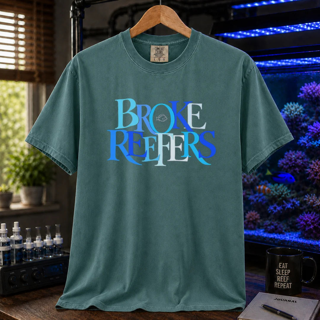 Saltwater aquarium graphic t-shirt featuring overlapping blue and white serif typography spelling Broke Reefers with a small fish outline on a green shirt