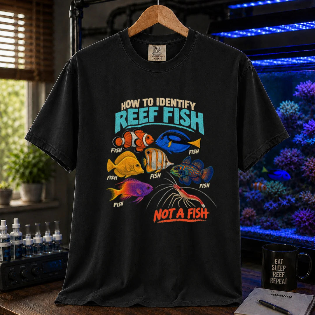 Saltwater aquarium graphic t-shirt featuring typography reading How To Identify Reef Fish above multiple fish labeled Fish and a cleaner shrimp labeled Not A Fish on a black shirt