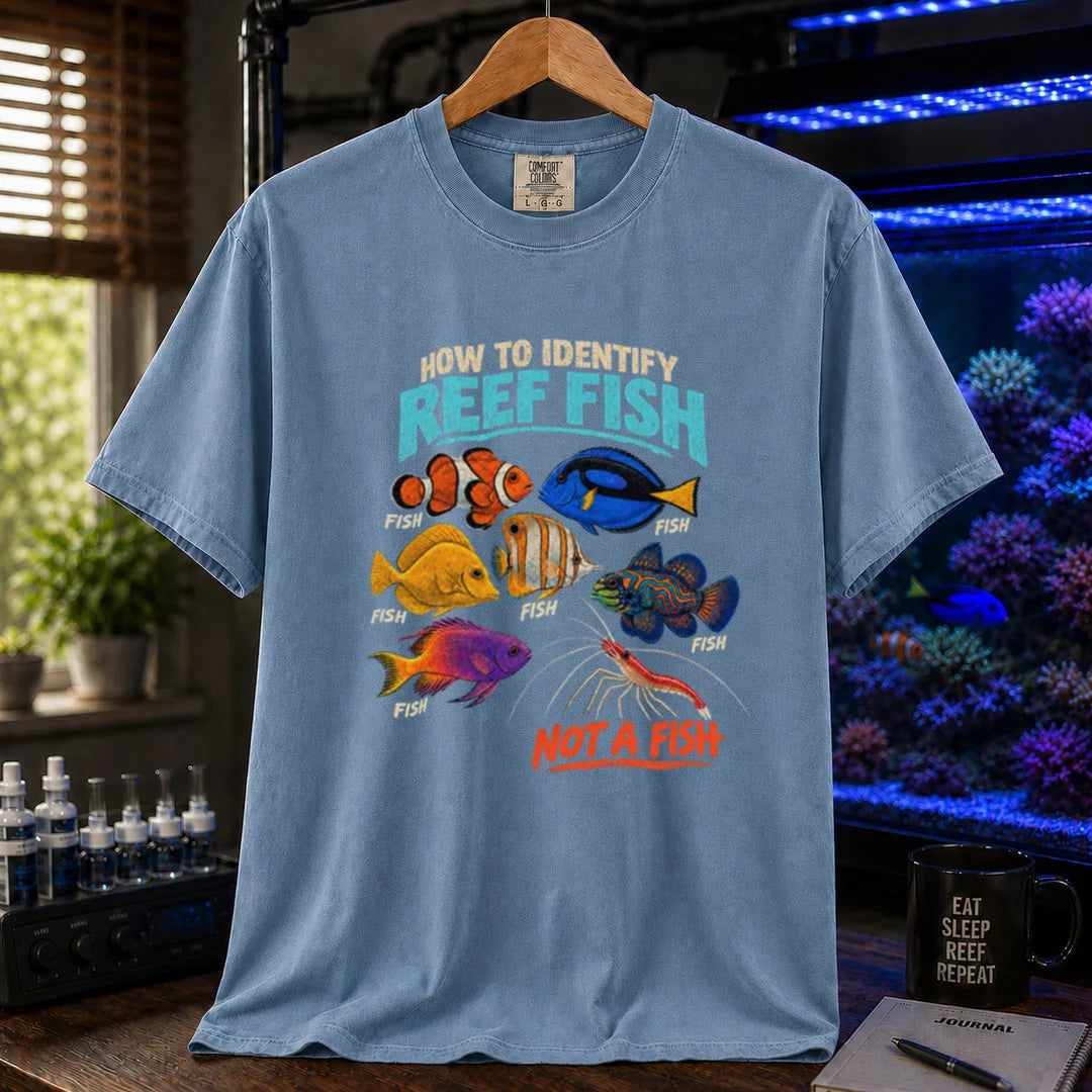 Saltwater aquarium graphic t-shirt featuring typography reading How To Identify Reef Fish above multiple fish labeled Fish and a cleaner shrimp labeled Not A Fish on a blue shirt