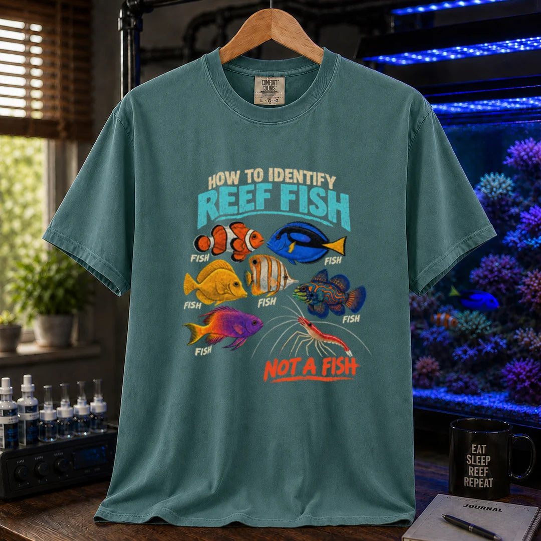 Saltwater aquarium graphic t-shirt featuring typography reading How To Identify Reef Fish above multiple fish labeled Fish and a cleaner shrimp labeled Not A Fish on a green shirt