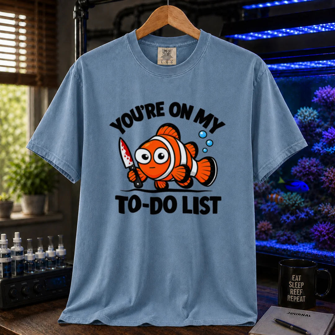 Saltwater aquarium graphic t-shirt featuring bold typography reading You're On My To-Do List framing an illustration of a clownfish holding a knife on a blue shirt