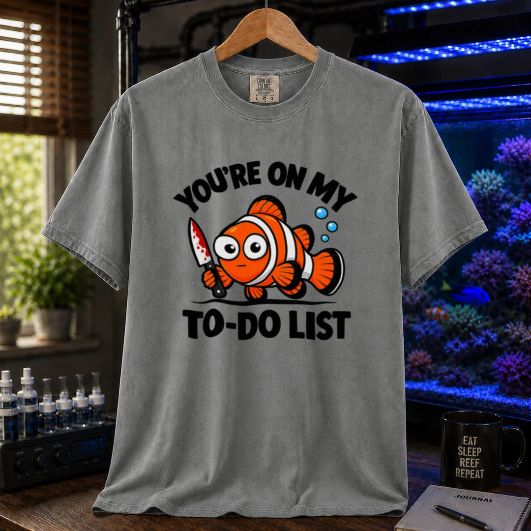 Saltwater aquarium graphic t-shirt featuring bold typography reading You're On My To-Do List framing an illustration of a clownfish holding a knife on a grey shirt