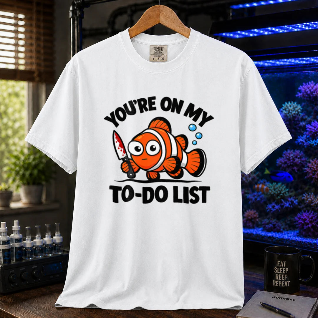 Saltwater aquarium graphic t-shirt featuring bold typography reading You're On My To-Do List framing an illustration of a clownfish holding a knife on a white shirt