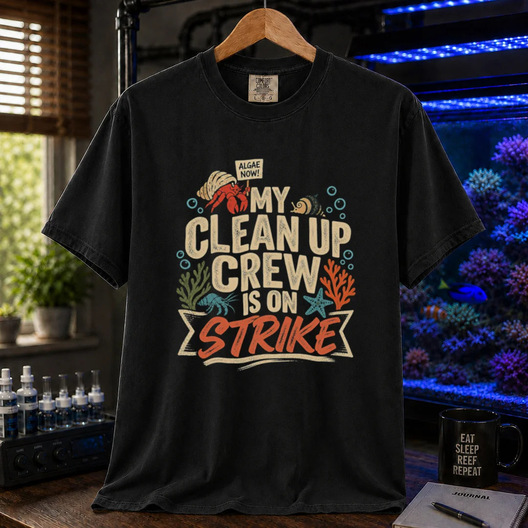 Saltwater aquarium graphic t-shirt featuring distressed typography reading My Clean Up Crew Is On Strike with illustrations of a hermit crab holding a protest sign and other marine cleanup animals on a black T-Shirt