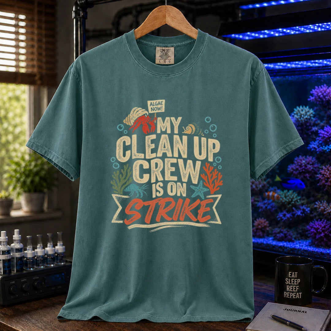 Saltwater aquarium graphic t-shirt featuring distressed typography reading My Clean Up Crew Is On Strike with illustrations of a hermit crab holding a protest sign and other marine cleanup animals on a green T-Shirt