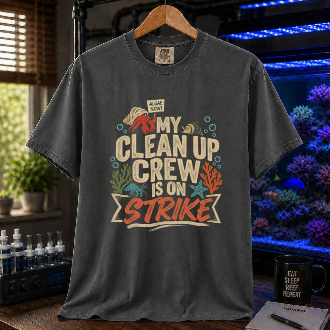 Saltwater aquarium graphic t-shirt featuring distressed typography reading My Clean Up Crew Is On Strike with illustrations of a hermit crab holding a protest sign and other marine cleanup animals on a dark grey T-Shirt
