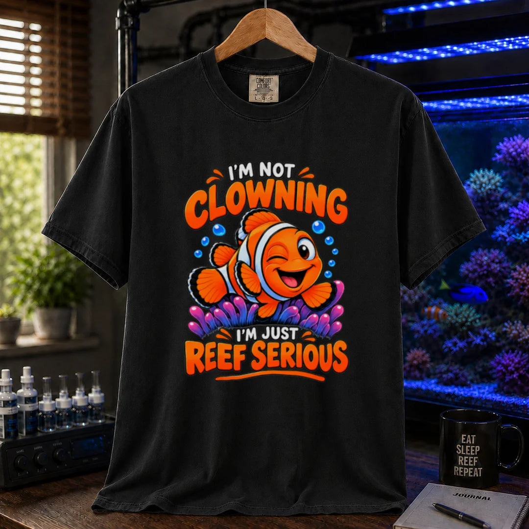 Saltwater aquarium graphic t-shirt featuring bold typography reading I'm Not Clowning I'm Just Reef Serious with a winking clownfish illustration on a black T-Shirt
