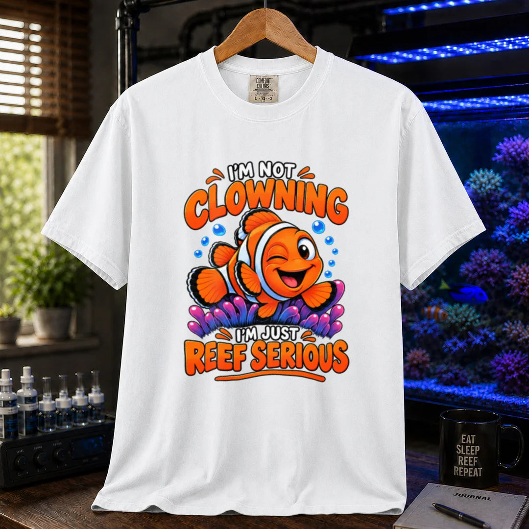 Saltwater aquarium graphic t-shirt featuring bold typography reading I'm Not Clowning I'm Just Reef Serious with a winking clownfish illustration on a white T-Shirt