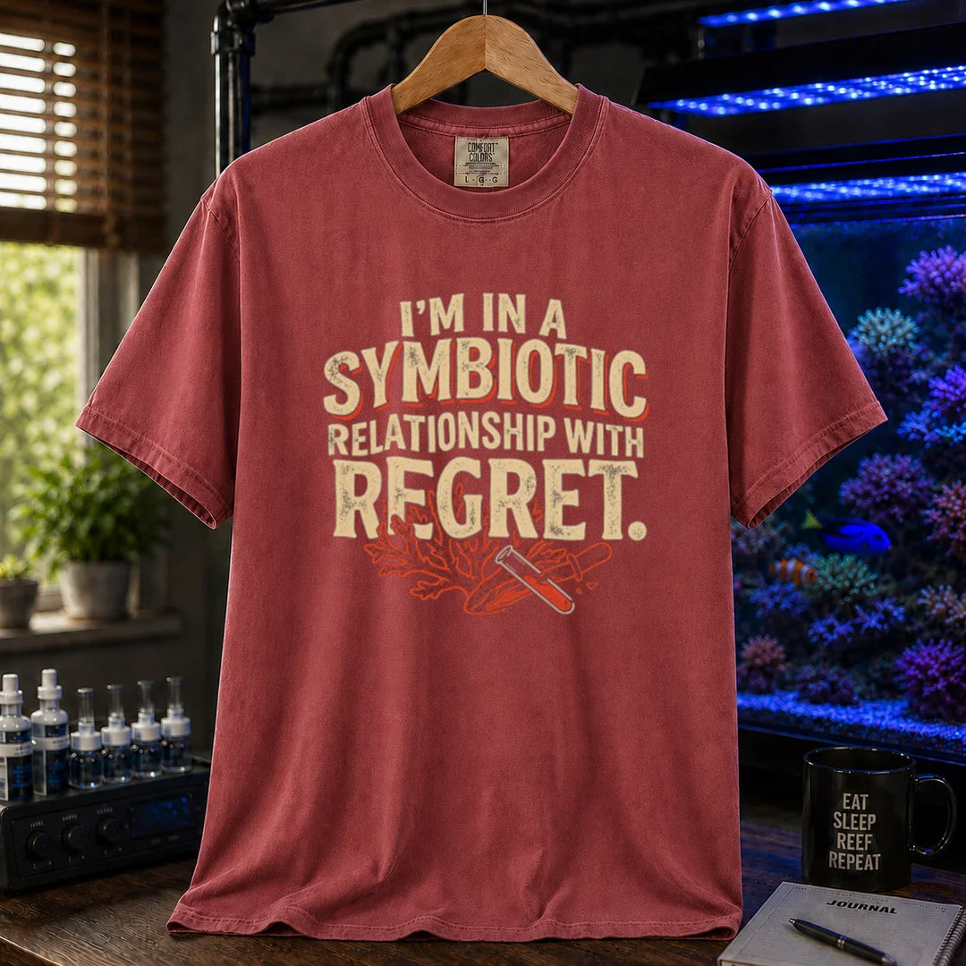 Saltwater aquarium graphic t-shirt featuring distressed typography reading I'm In A Symbiotic Relationship With Regret with coral and pipette illustrations on a maroon, red T-Shirt