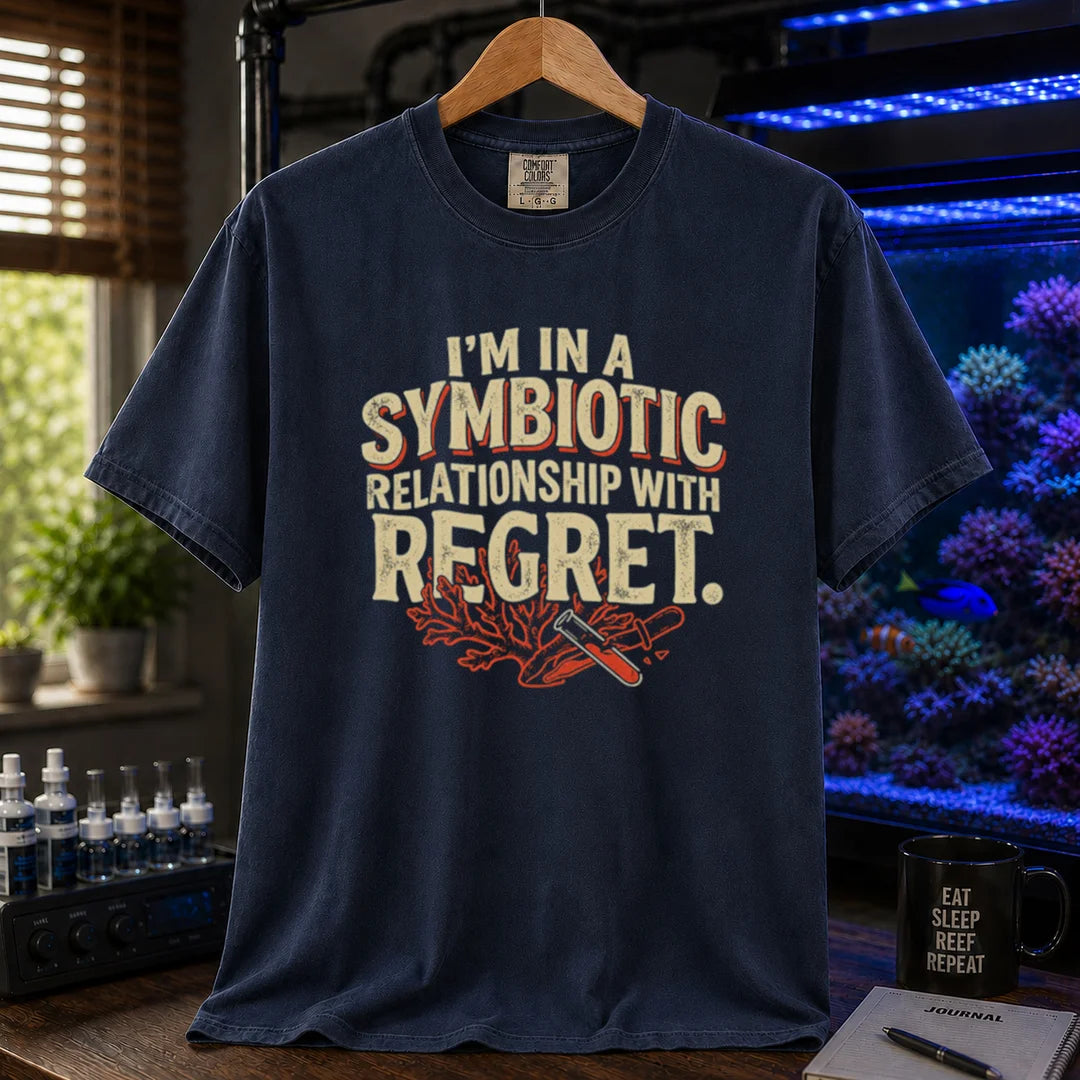 Saltwater aquarium graphic t-shirt featuring distressed typography reading I'm In A Symbiotic Relationship With Regret with coral and pipette illustrations on a navy T-Shirt