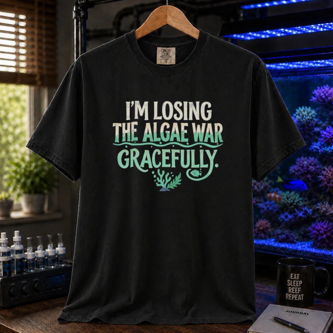 Saltwater aquarium graphic t-shirt featuring distressed typography reading I'm Losing The Algae War Gracefully with coral and fish illustrations on a black T-Shirt