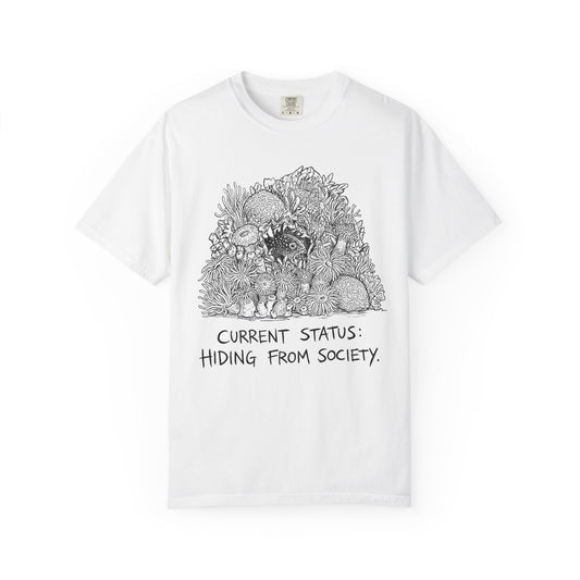 CURRENT STATUS: HIDING FROM SOCIETY graphic t-shirt design featuring bold distressed lettering and a detailed reef creature nestled within a colourful coral reef illustration.
