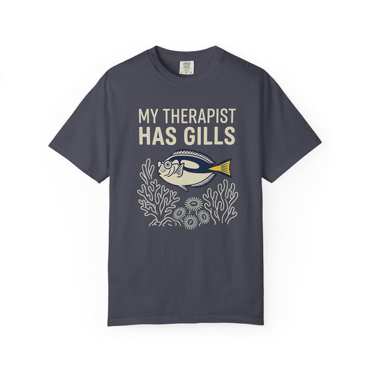 MY THERAPIST HAS GILLS graphic t-shirt design featuring bold lettering and a colourful saltwater reef aquarium scene with a tropical fish illustration.