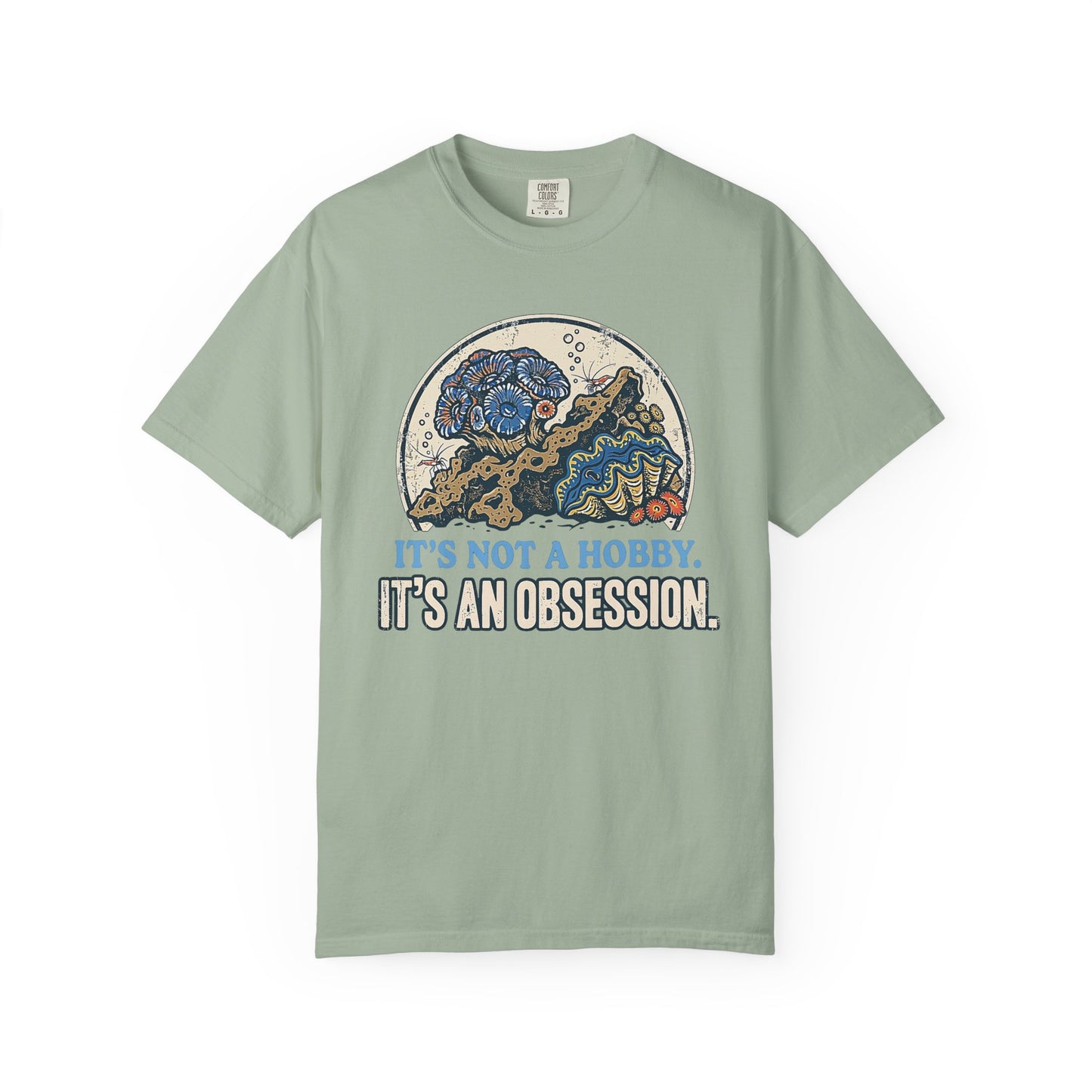 Broke Reefers saltwater aquarium graphic t-shirt featuring a detailed, vintage-style circular illustration of a thriving reef scene with the text: IT'S NOT A HOBBY. IT'S AN OBSESSION., light green crew neck tee
